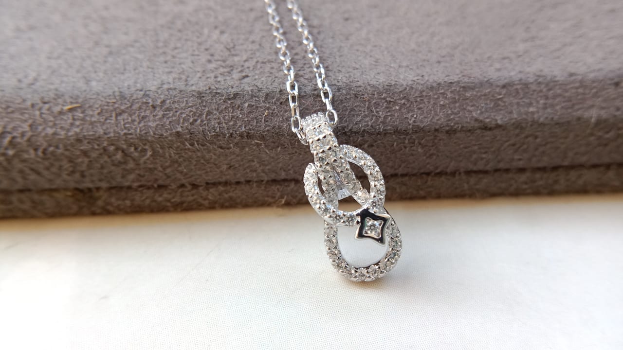 Silver necklace with a pendant on a wooden surface