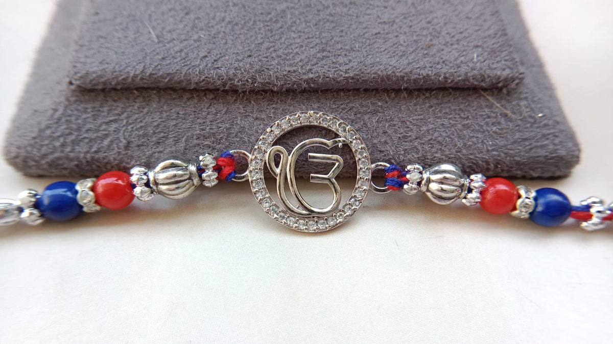 925 Silver EK OmKar Rakhi with Red Blue Beads & Clear Stone Detail